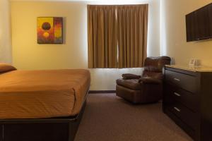 une chambre d'hôtel avec un lit et une chaise dans l'établissement BONITTO INN® Tampico Aeropuerto, à Tampico