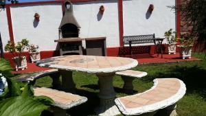 uma mesa de piquenique e dois bancos num quintal em El Perlindango em Villademar