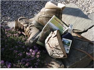 a bottle of wine sitting next to a pair of boots at Hotel Zur Post in Roßbach