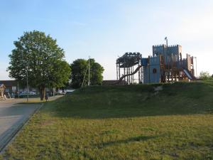 um parque com um parque infantil no topo de uma colina em Haus am Haff em Karnin