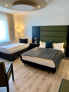 a hotel room with two beds in a room at Boutique Hotel Goldene Henne in Wolfsburg +128 photos