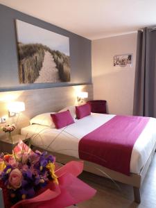 a hotel room with two beds and a painting on the wall at Atoll Hotel restaurant in Fréjus