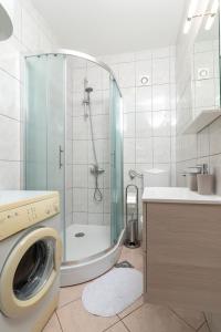 y baño con ducha y lavadora. en Apartments Ivan en Trogir
