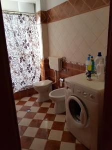 a bathroom with a toilet and a washing machine at Big apartment in Orikum +21 photos