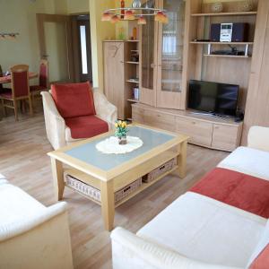 un soggiorno con tavolino e TV di Haus Agnes FeWo 2 a Malborn