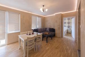 a living room with a table and a couch at Kosev Apartment in Veliko Tŭrnovo +8 photos