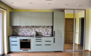 a kitchen with white cabinets and a sink at Apartments Franny's Bees in Vilnius