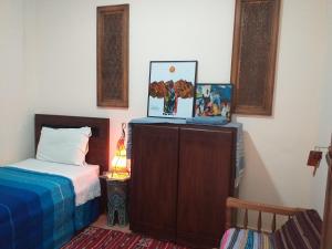 a bedroom with a bed and a dresser with a picture at dar wassim el ghali in Rabat