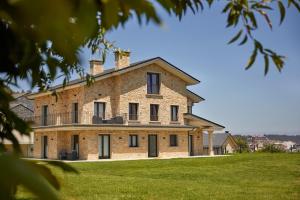 a large brick house on a grassy field at Apartamentos Arumes do Mar e Montaña - Viveiro in Viveiro