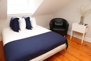 1 dormitorio con 1 cama y 1 silla negra en Charming & Stylish Studio on Beacon Hill #15, en Boston