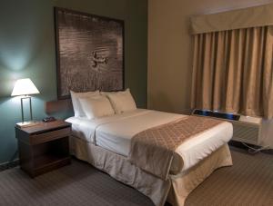 a hotel room with a large bed and a window at Super 8 by Wyndham Dauphin in Dauphin