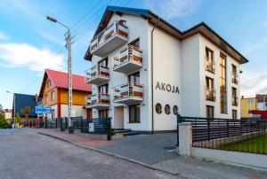 - un bâtiment blanc avec balcon dans une rue dans l'établissement Akoja, à Władysławowo