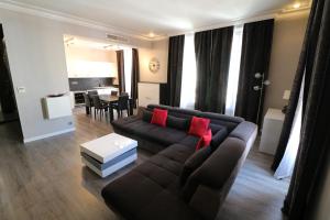 een woonkamer met een bruine bank en rode kussens bij Quality 2 bedroom 9 mins from the Palais 342 in Cannes