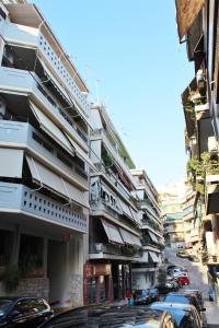 a city street with cars parked in front of buildings at Athenian Hub Luxe Loft in Athens