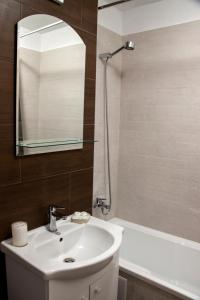 a bathroom with a sink and a mirror and a tub at Ana Cristina Apartament in Sighişoara +7 photos