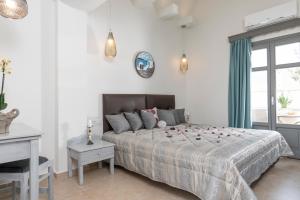 a bedroom with a bed and a desk and a window at Smaragdi Hotel in Perivolos