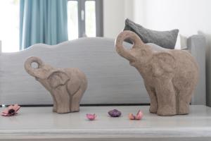 two elephant statues on a table next to a bed at Smaragdi in Perivolos