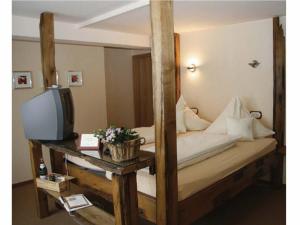 a bedroom with a wooden bunk bed with a television at Hotel Zur Post in Roßbach
