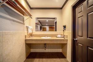 W łazience znajduje się umywalka i lustro. w obiekcie Oak Park Motel w mieście Monrovia