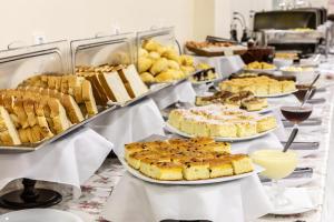 a table full of cakes and pastries on a table at Bogari Hotel in Foz do Iguaçu