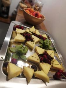 um prato de queijo e fruta numa mesa em B&B Extremo Sud em Portopalo
