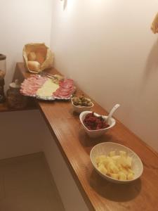 a wooden counter with three bowls of food on it at B&B Extremo Sud in Portopalo