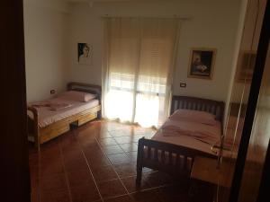 two beds in a room with a window at Big apartment in Orikum