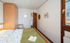 1 dormitorio con 1 cama, 1 silla y 1 ventana en Sylt - Haus Christianenhöhe - App 33, en Westerland