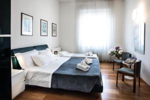 una camera da letto con un grande letto con asciugamani di La Magnifica a Firenze