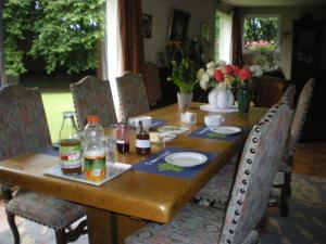 Una mesa de madera con botellas y bebidas encima. en La Petite Londe, en Biéville-Beuville