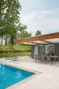 an outdoor patio with a table and chairs and a pool at Villa Helios in Sveti Petar u Šumi