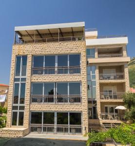 um edifício de apartamentos com grandes janelas e varandas em ApartHotel Stijovic em Bar