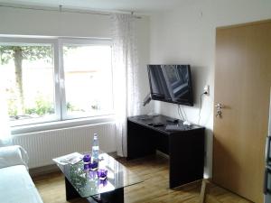 ein Wohnzimmer mit einem TV und einem Couchtisch in der Unterkunft Ferienhaus Schloss-Garten in Kapellen-Drusweiler