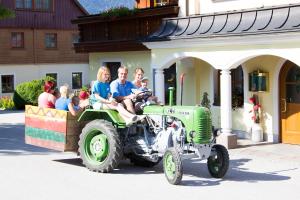 a group of people riding on the back of a tractor at Reisslerhof in Gröbming