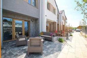 a patio with couches and chairs next to a building at Baltic Pearl in Ustka