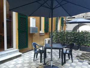 una mesa y sillas con una sombrilla en el patio en Timeline camere in La Spezia en La Spezia