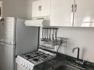 a white kitchen with a stove and a sink at Elena's Aparment in León