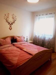 una camera da letto con un letto con un piumone rosso e una finestra di Apart Zireiner See a Kramsach