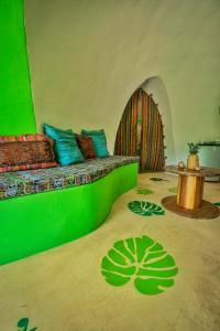 um quarto com uma cama com almofadas verdes e azuis em Green Moon Lodge em Montezuma