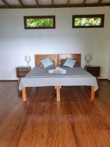 a large bed in a room with two windows at Ataraxia in Bastimentos