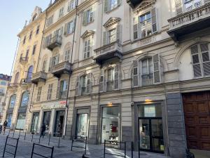 un grande edificio su una strada cittadina con panchine di fronte di Ramiere Porta Nuova a Torino
