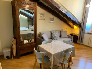 ein Wohnzimmer mit einem Tisch, einem Sofa und einem Spiegel in der Unterkunft Ramiere Porta Nuova in Turin