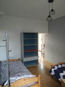 1 dormitorio con cama y estante para libros en Przy Leśnej en Szklarska Poręba