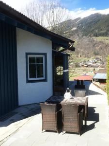 een patio met een tafel en stoelen voor een huis bij AlpenApartment in Bramberg am Wildkogel