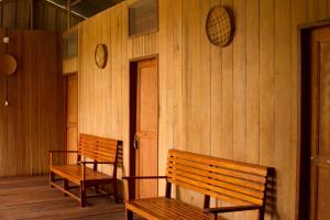 2 bancos en una habitación con paredes de madera en La Ceiba, Amazonas, en Leticia