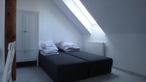 a small bed in a room with a window at Gaski Na Fali in Gąski