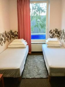 two beds in a room with a window at Harbour Hostel Tallinn in Tallinn
