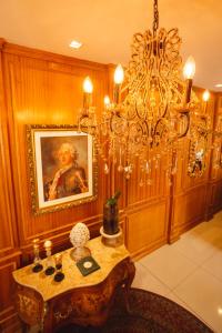 una sala da pranzo con tavolo e lampadario pendente di Pousada Luis XV a Campos do Jordão