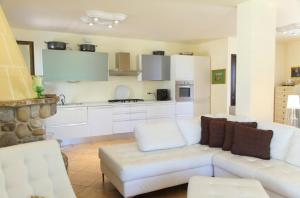 Il comprend un salon avec un canapé blanc et une cuisine. dans l'établissement Villa lipari, à Cefalù