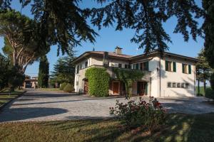 una grande casa bianca con edera di Villa Paola Holidays a SantʼAngelo in Vado